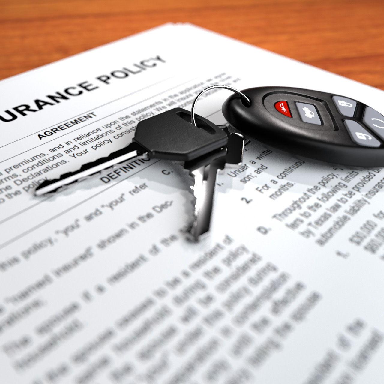 Close up view of an insurance policy with car keys on top