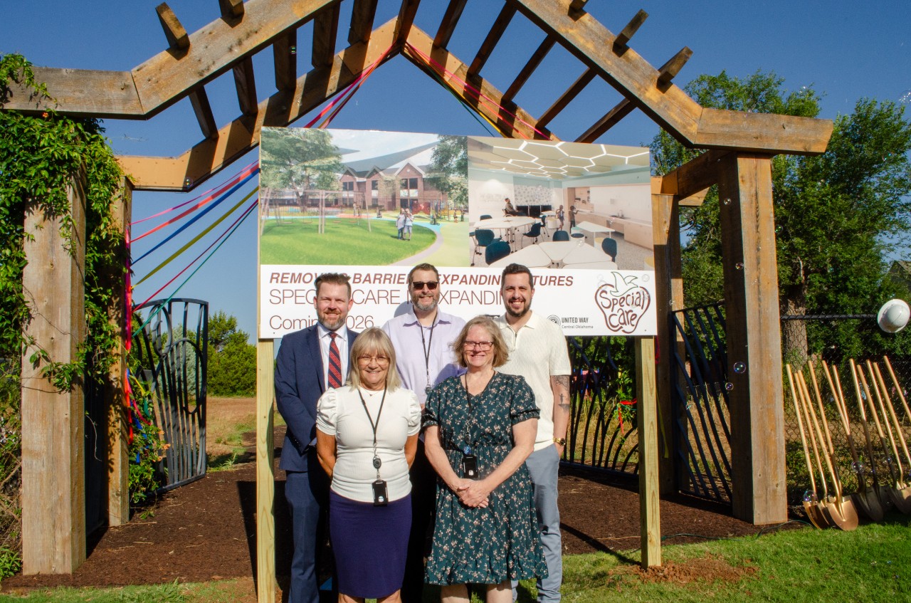 GMO team stands in front of project renderings.