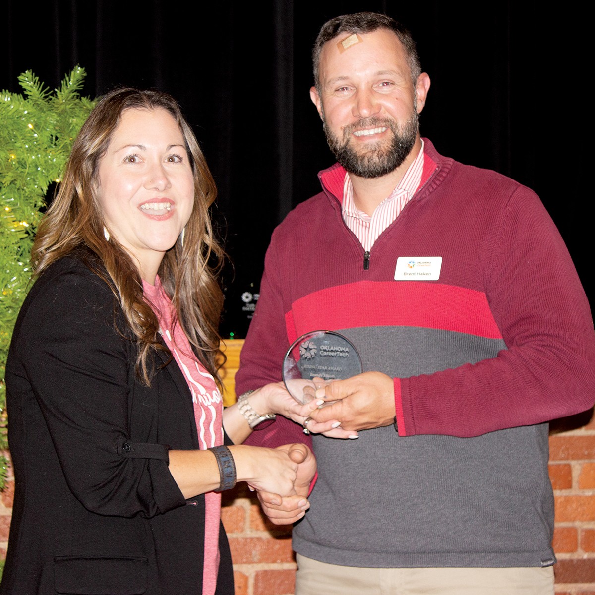 Brandy Elliott, data quality coordinator in the Oklahoma CareerTech Information Management division, received the Rising Star Award. With her is Brent Haken, state director.