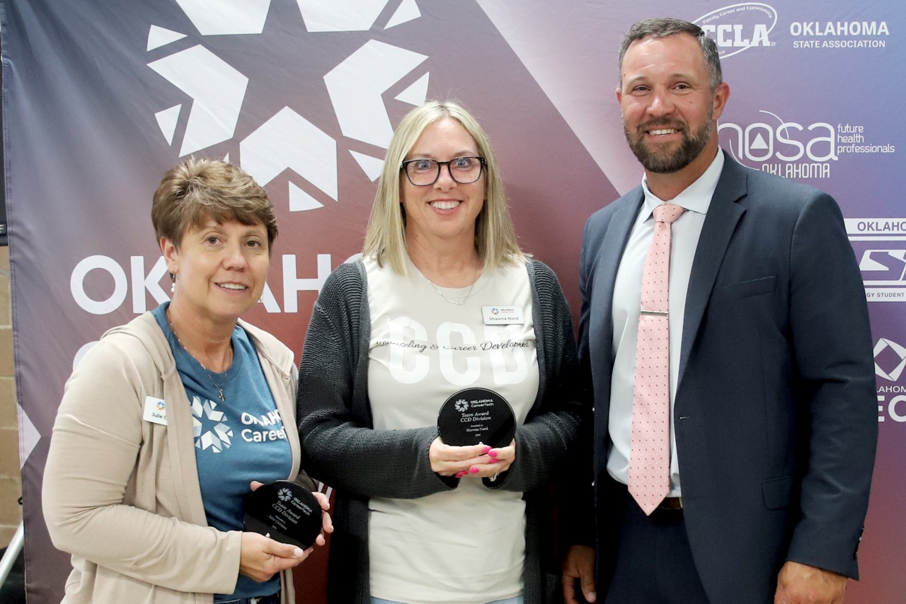 Julie Childers, left, counseling and career development academic coordinator, and Shawna Nord, center, CCD manager, received the Team Award at the 2025 ODCTE state staff meeting. With them is CareerTech State Director Brent Haken.