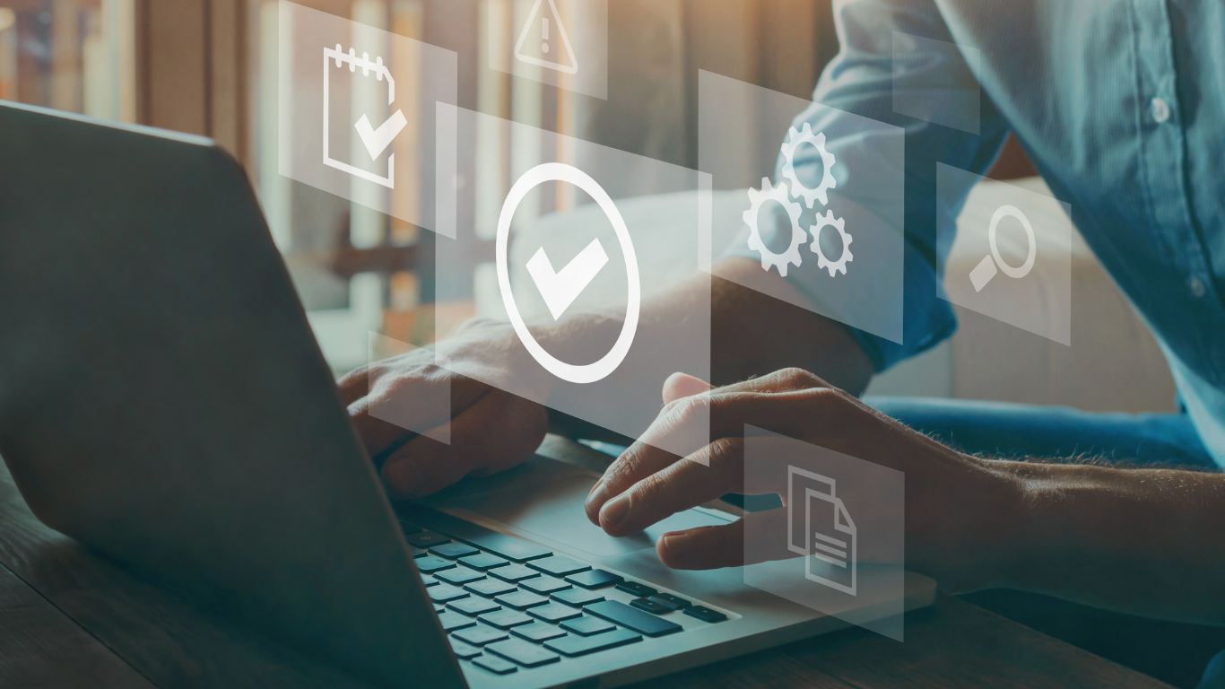 Man sitting at a desk, typing on a laptop with multiple icons floating in the air