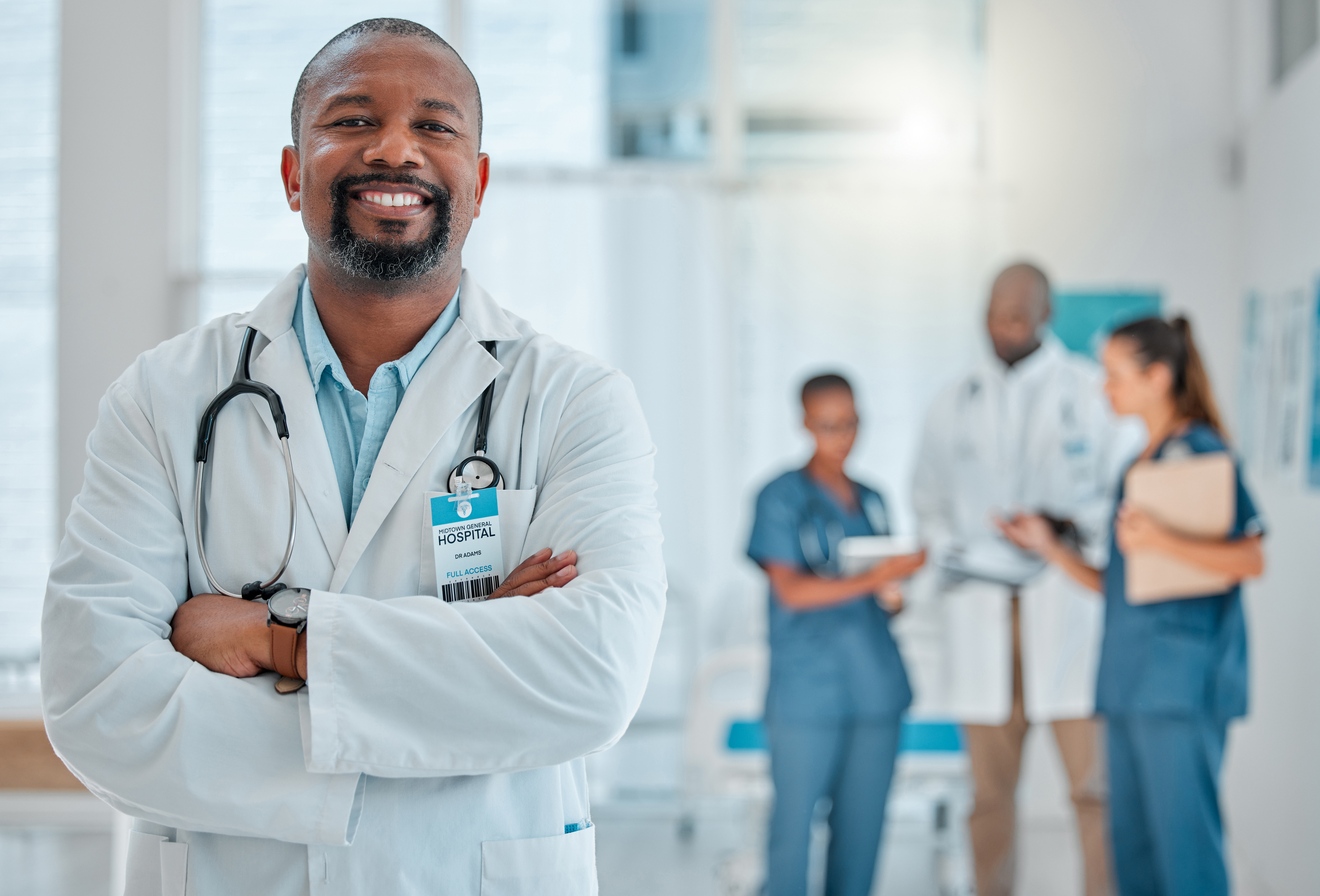 Mature african american male doctor standing with his arms crossed while working at a hospital. One