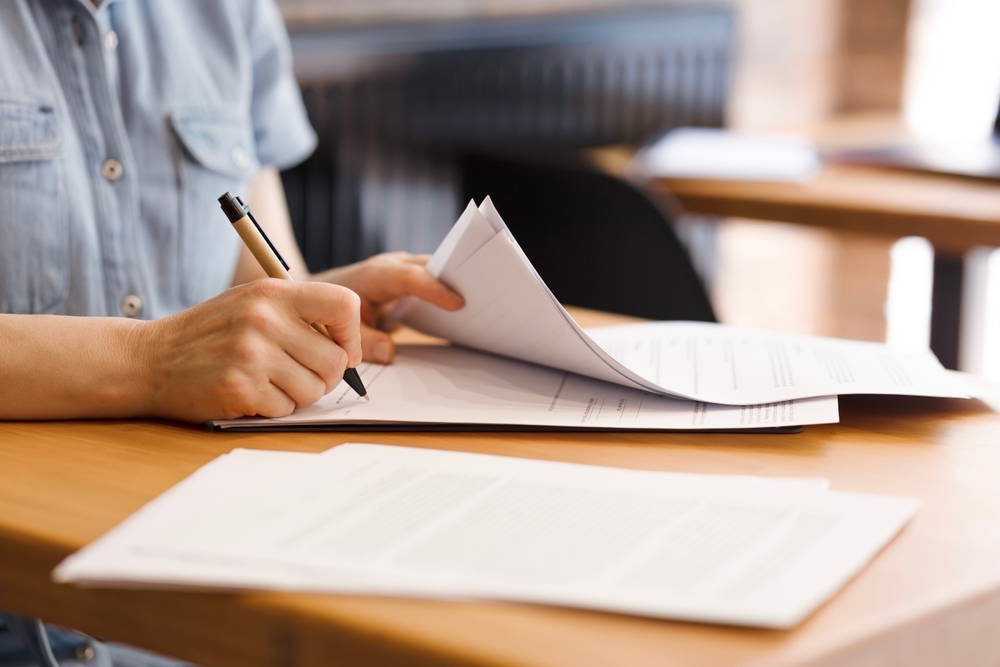 Female hands with pen signing documents