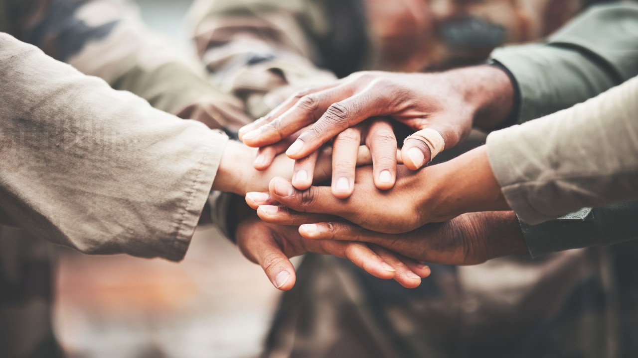 Hands stacked on top of each other as a team rallying together. 
