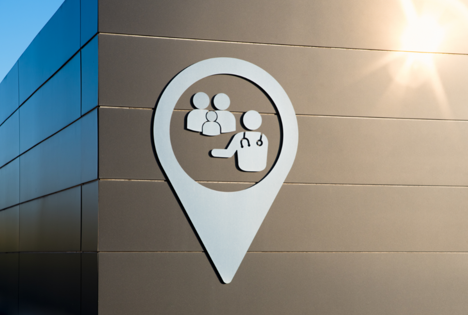 corner of a brown building with a logo of a physician or physician assistant meeting with a family