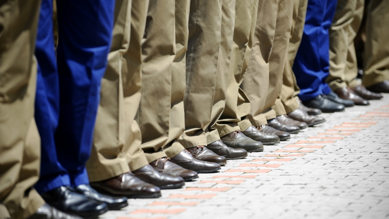 People standing in a line side by side in kaki and blue pants