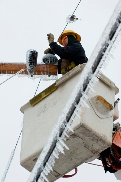 An electrical worker in a lift box fixing power lines.
