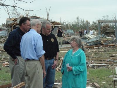 Officials speak with resident whose home was destroyed.