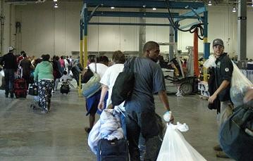 People with bags of  belonging walking toward and exist. 