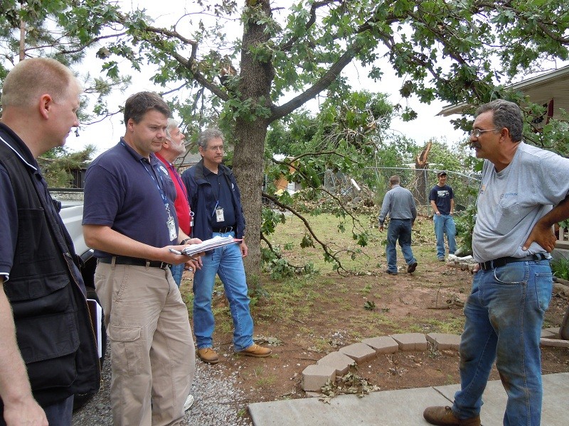 Five men talking together. 