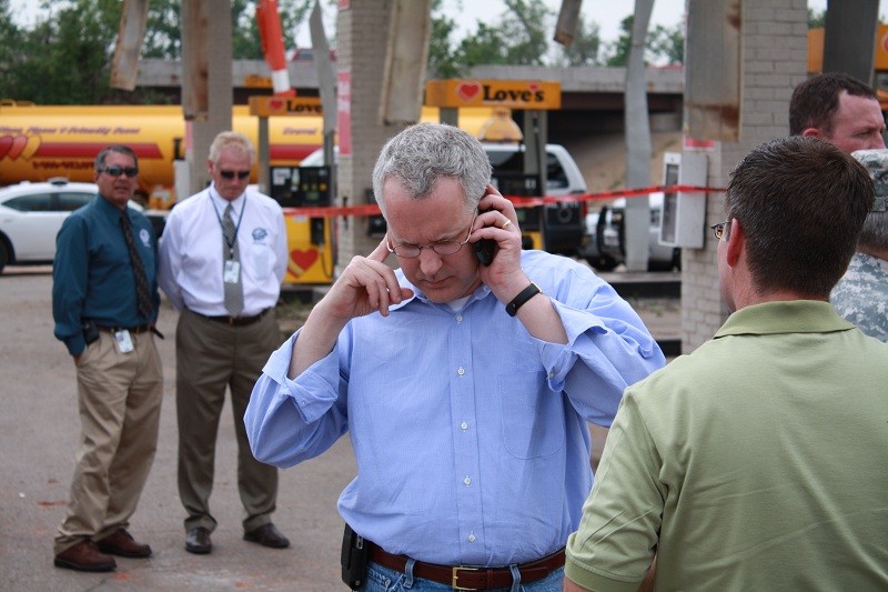 Gov. Henry on a cell phone outside at a Love's parking lot. 