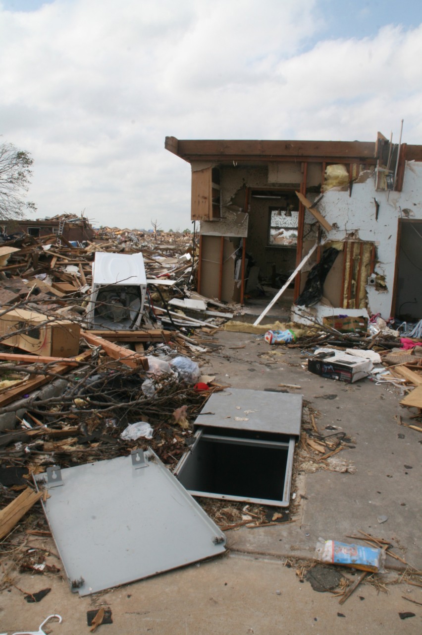 Storm shelter with tornado debris all around.