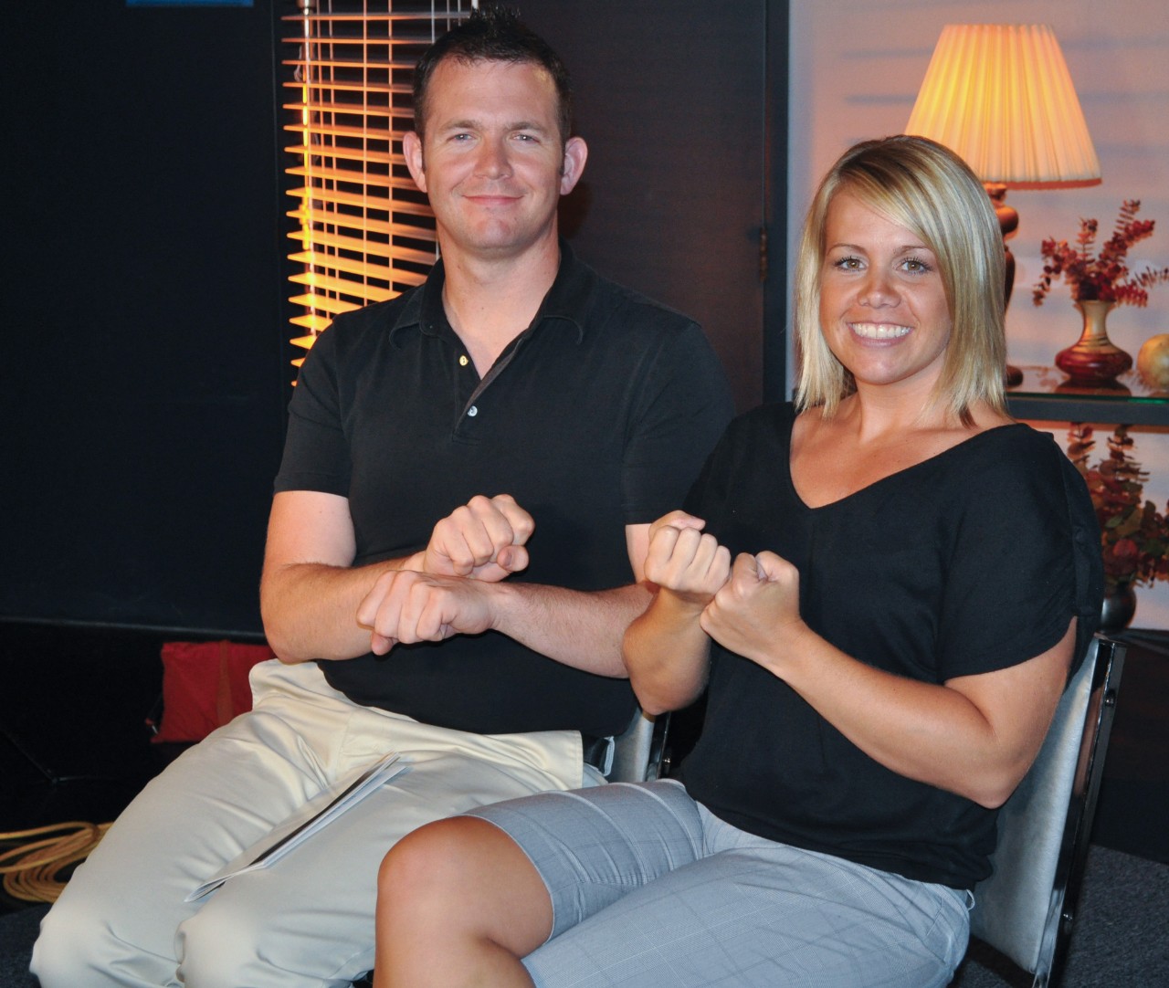 A man and woman seat showing signs for support and and service..