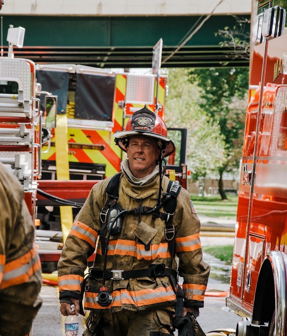 a fireman walking down a street next to a fire truck
