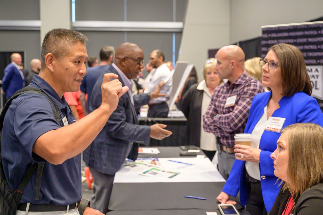 Two attendees engaging with Public Safety booth staff.