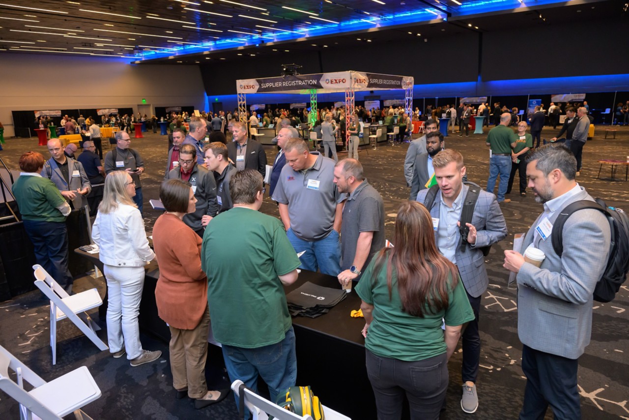 An overhead shot of the expo ballroom with attendees and employees interacting