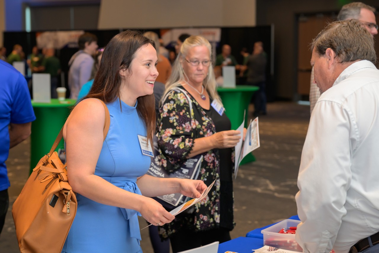 Attendee smiling at booth employee
