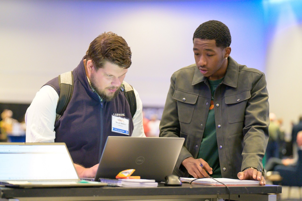 Staff member and attendee going through the bidder enrollment process together