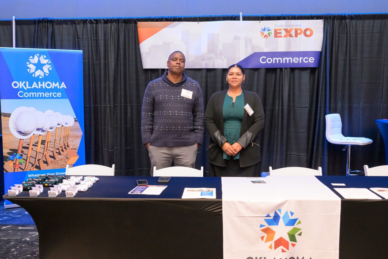 Two state staff members smiling at the Commerce booth