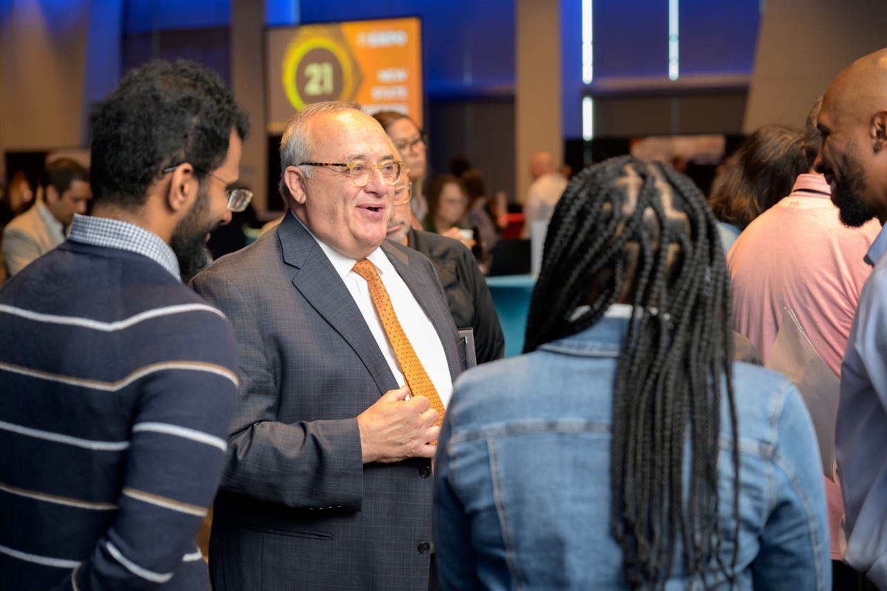 Crowd of attendees smiling and talking