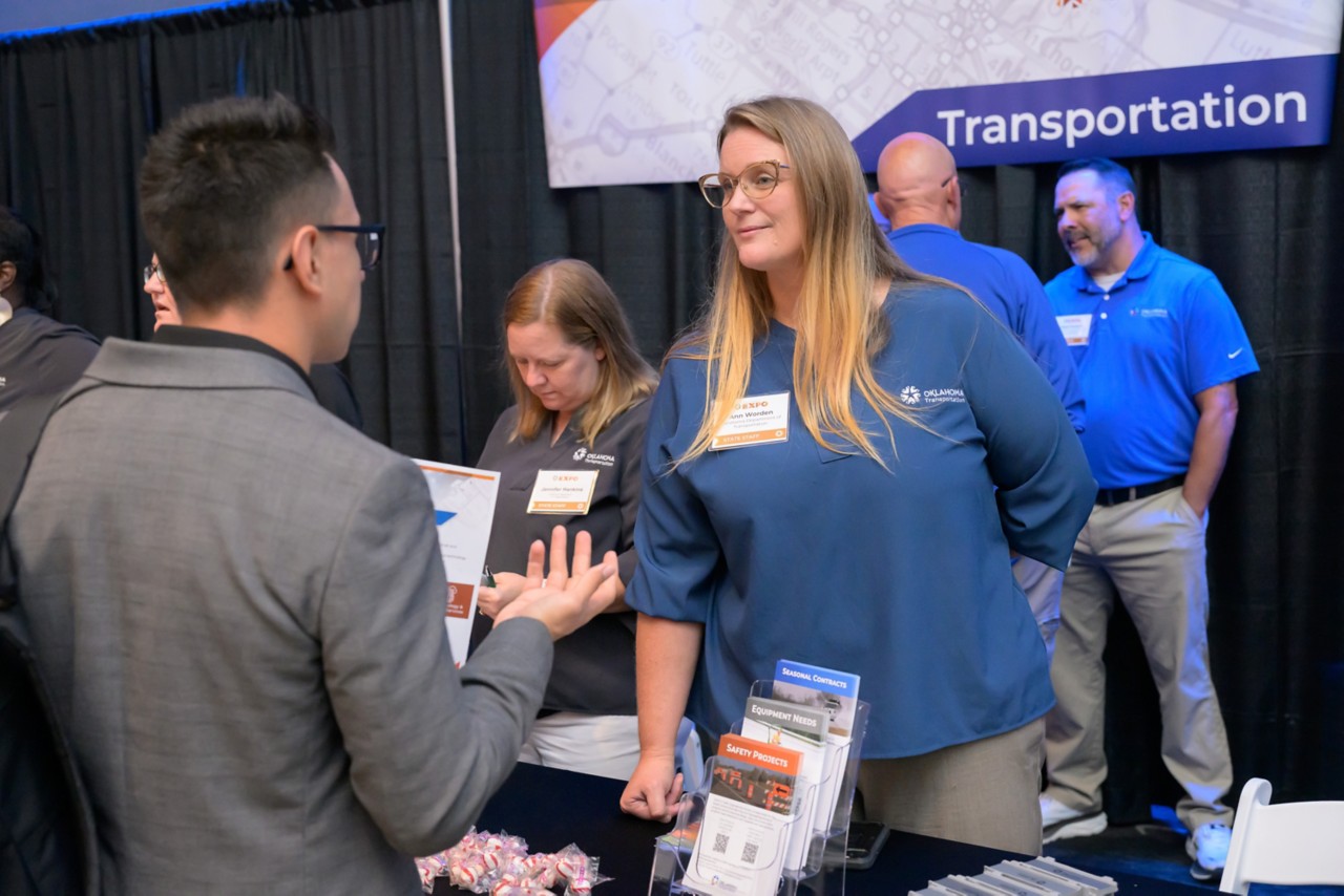 Attendees and staff members interact at the Transportation booth