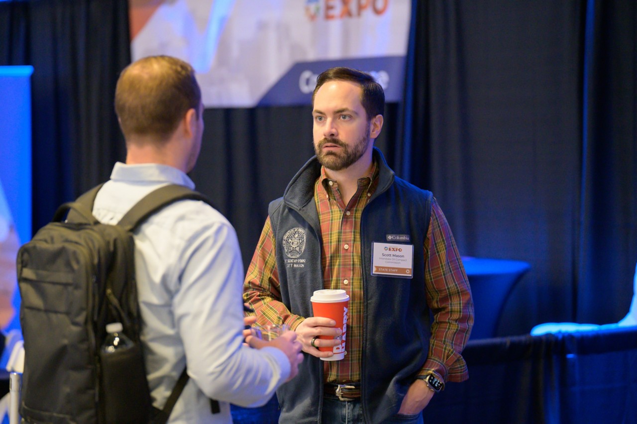 Scott Mason and attendee talking at Energy and Environment booth