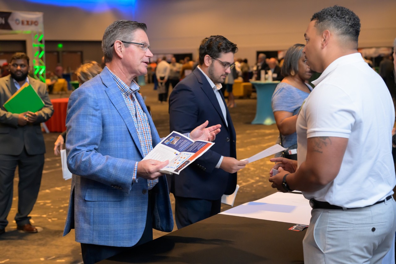 Employee giving flyers to two attendees