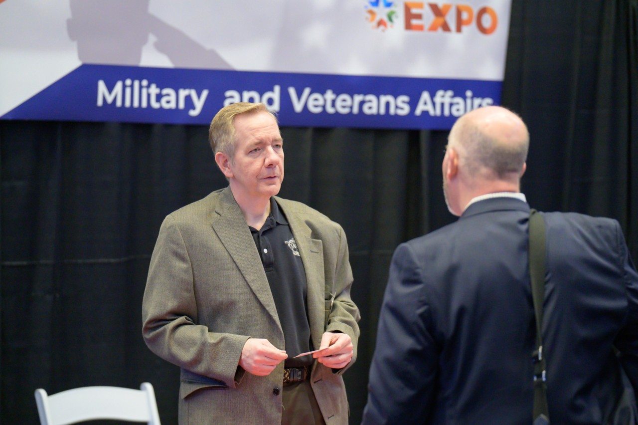 Military and Veterans Affairs staff member speaking with attendee