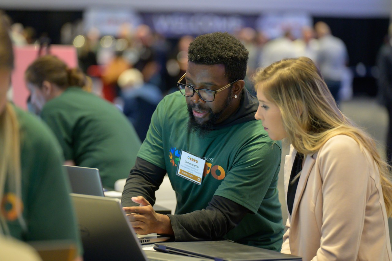Registration Specialist Jarren Carter assists attendee at Supplier Registration booth