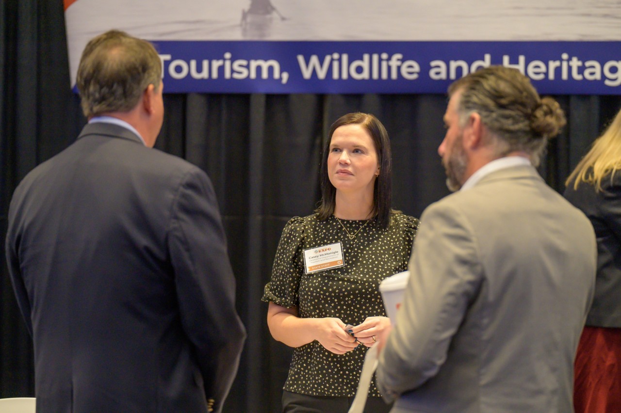 Tourism, Wildlife and Heritage staff member talking with two attendees