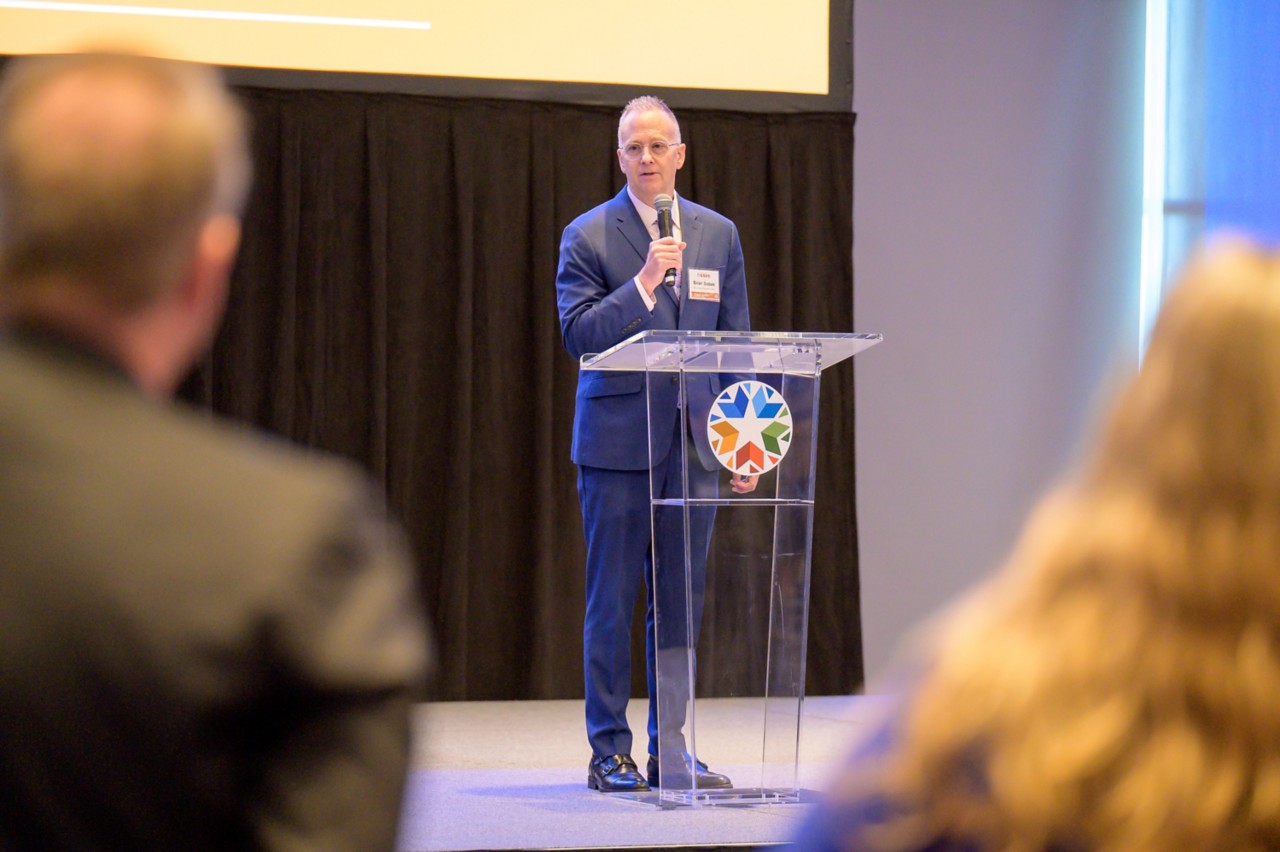 State COO Brian Bobek talks on stage at a podium