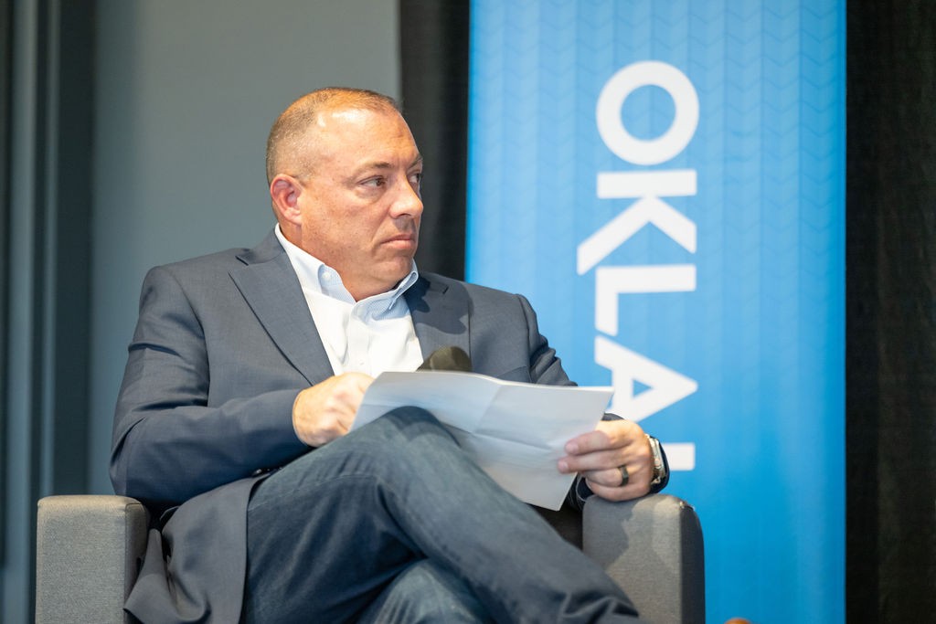 State CIO Dan Cronin listening and holding paper during luncheon panel