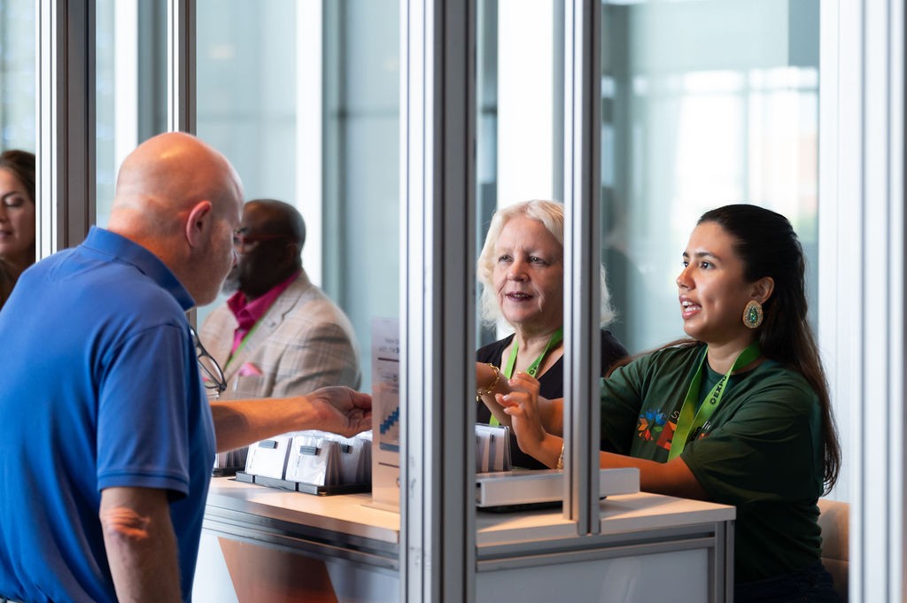 Event check-in staff talking to supplier attendee