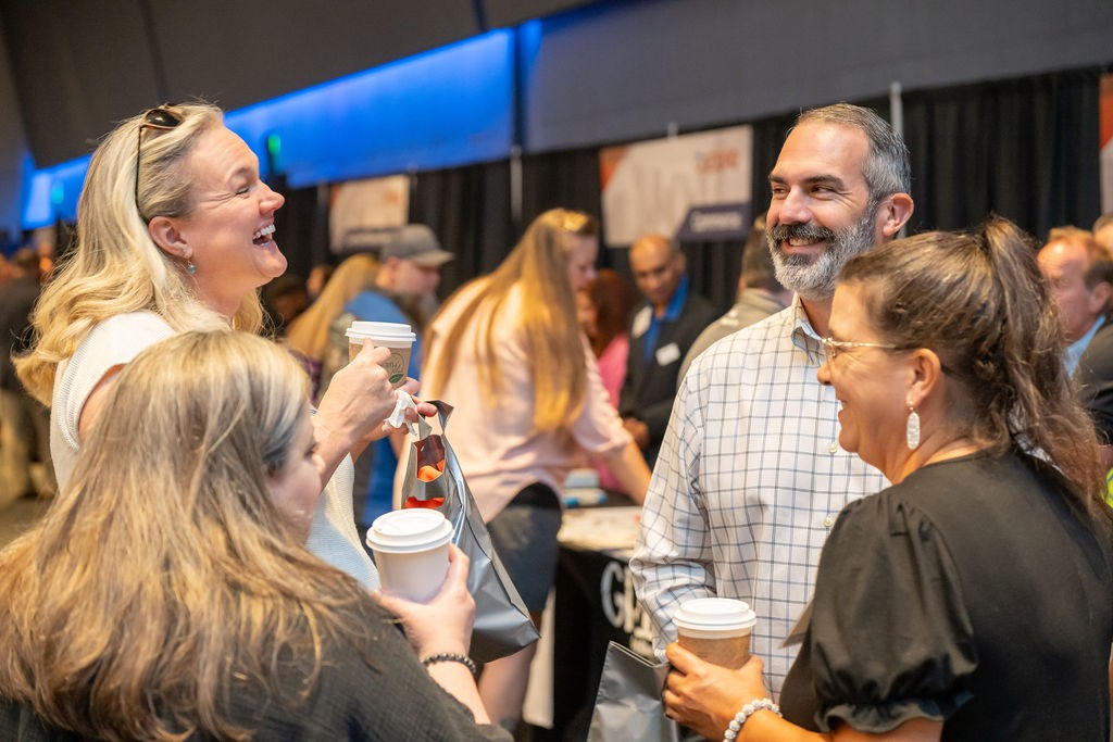 Four attendees smiling and laughing