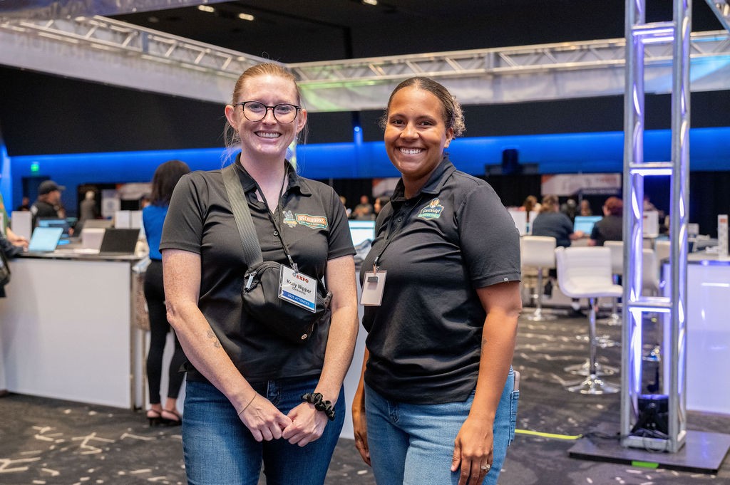 Attendees smiling in front of Supplier Registration booth