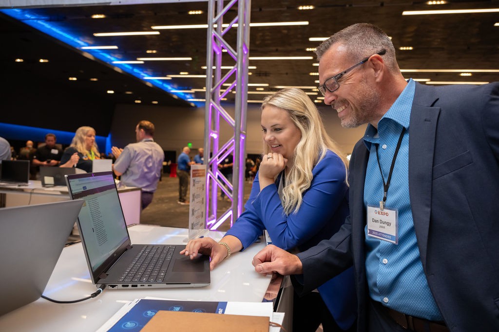 Two attendees registering at the Supplier Registration booth