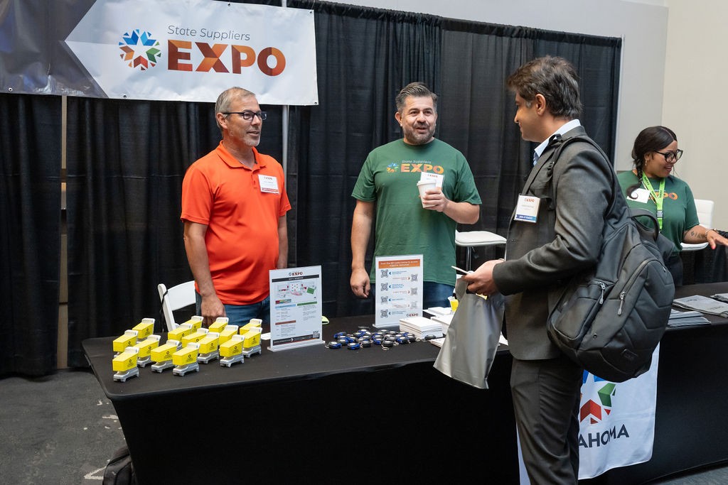 OMES Central Purchasinf staff greet attendee at Welcome booth