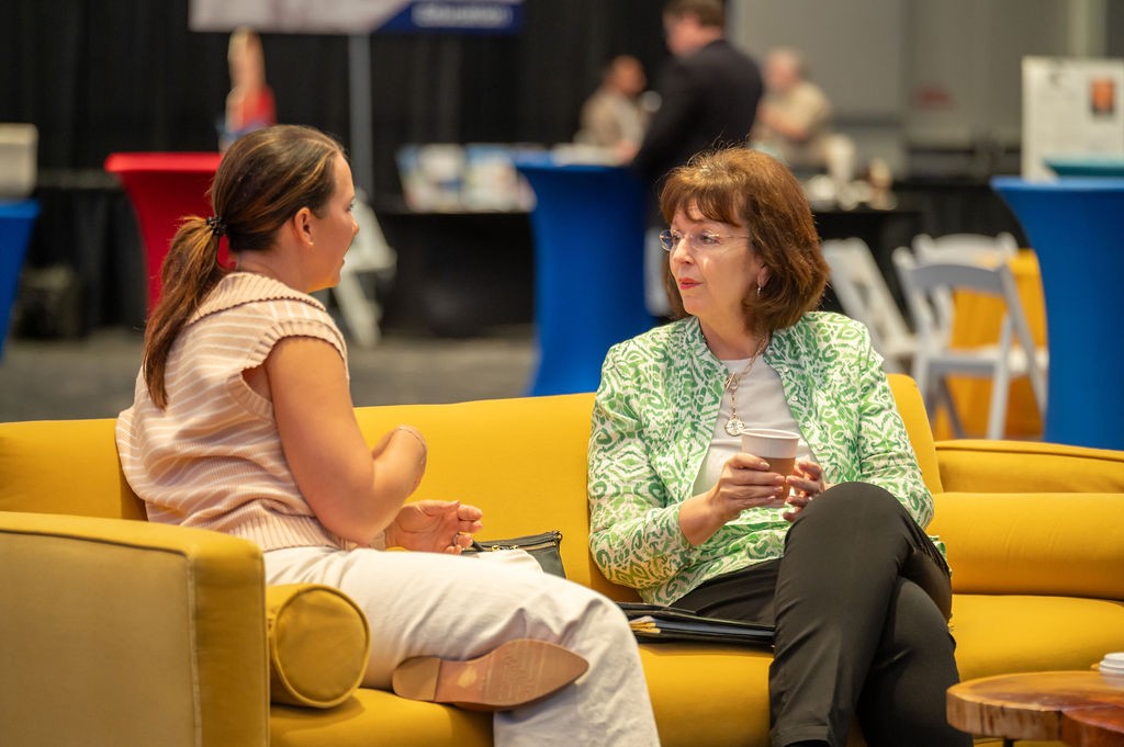 Two suppliers talk on yellow couch