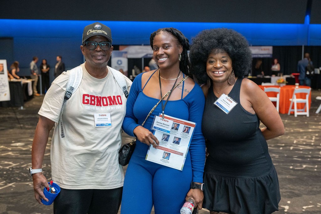 Three suppliers smiling together in ballroom