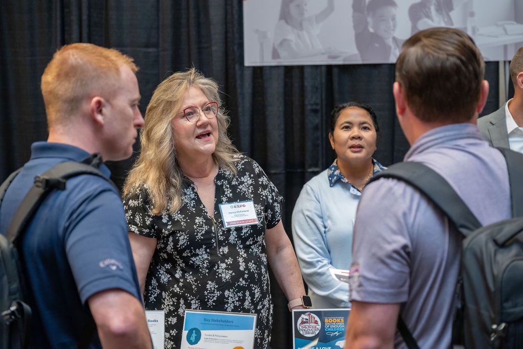 OSDE employees welcome attendees to Education booth
