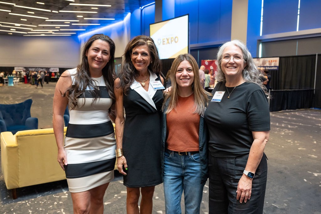 Four attendees standing together and smiling