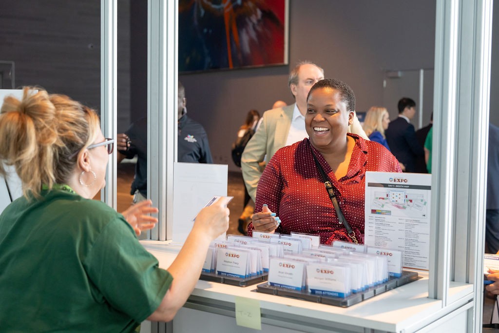 Supplier attendee smiles while checking into the event