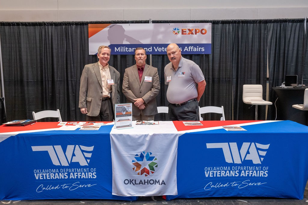 Three ODVA employees smile at Veterans and Military Affairs booth