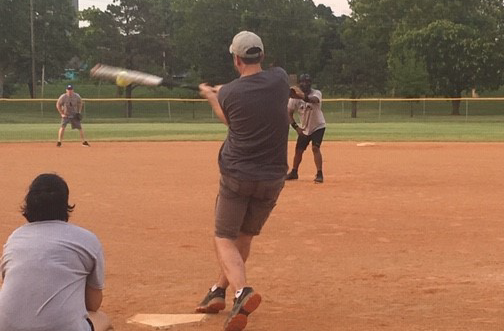 batter missing a softball pitch